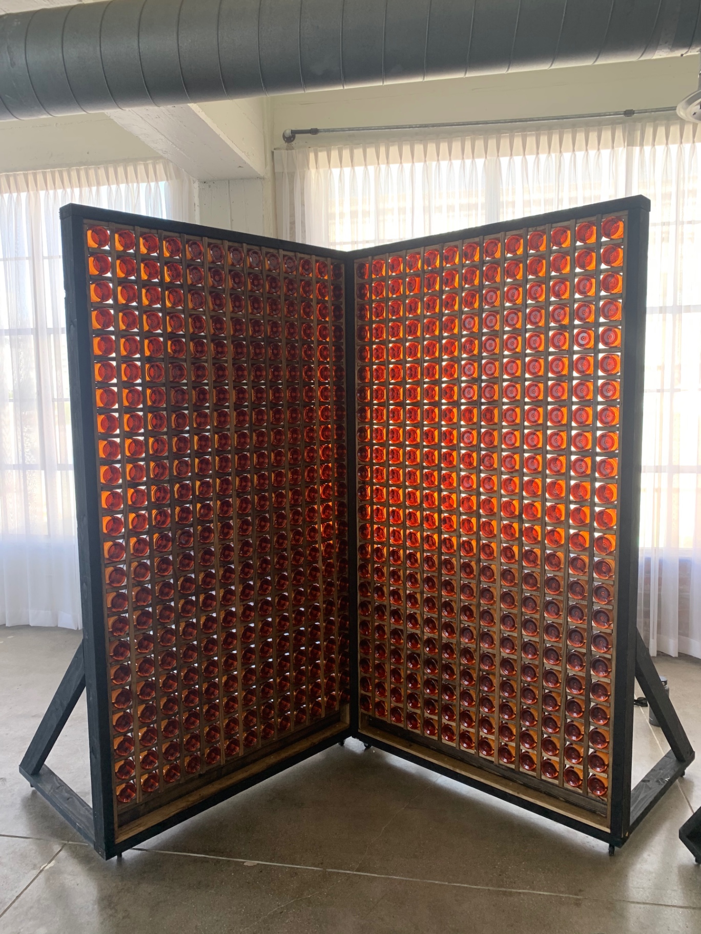 Amber Lens Room Divider — Salvaged marine lenses · blackened steel frame